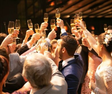 Elegantly dressed guests with champagne glasses toast together at a wedding reception inside Drugan’s Castle Mound in Holmen, WI.